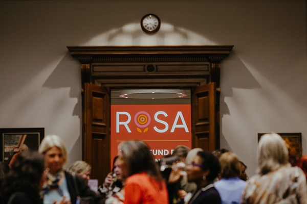 view through doors to show Rosa logo projected on a wall.
